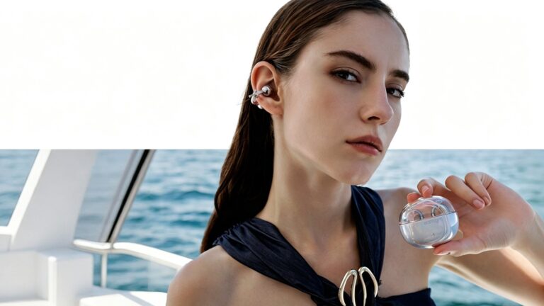 Woman wearing a silver clip-on open-ear earbud and holding a transparent charging case